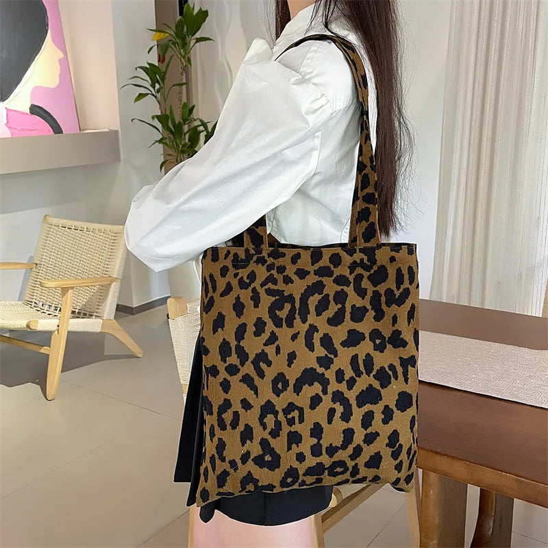 Corduroy leopard print shoulder bag in vertical square shape with open pocket, phone pocket, and document pocket.