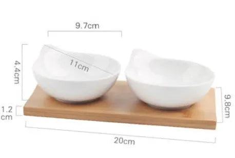 Porcelain ceramic dried fruit dish with three snack compartments on a wooden serving board.