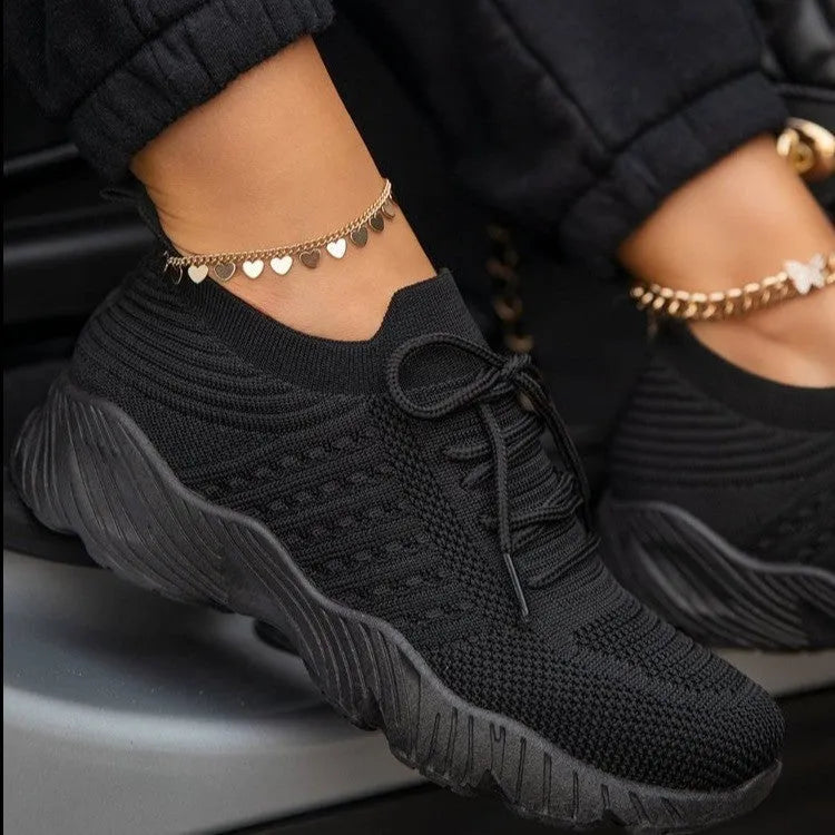 Women's white thick-sole dad-style sports sneakers on a neutral background.