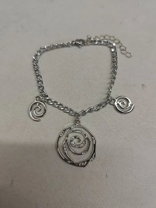 Gold spiral donut charm jewellery set showing necklace, bracelet and earrings on a white background