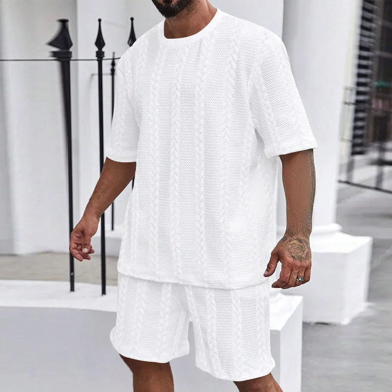 Knitted solid colour short sleeve pullover and matching shorts laid flat.