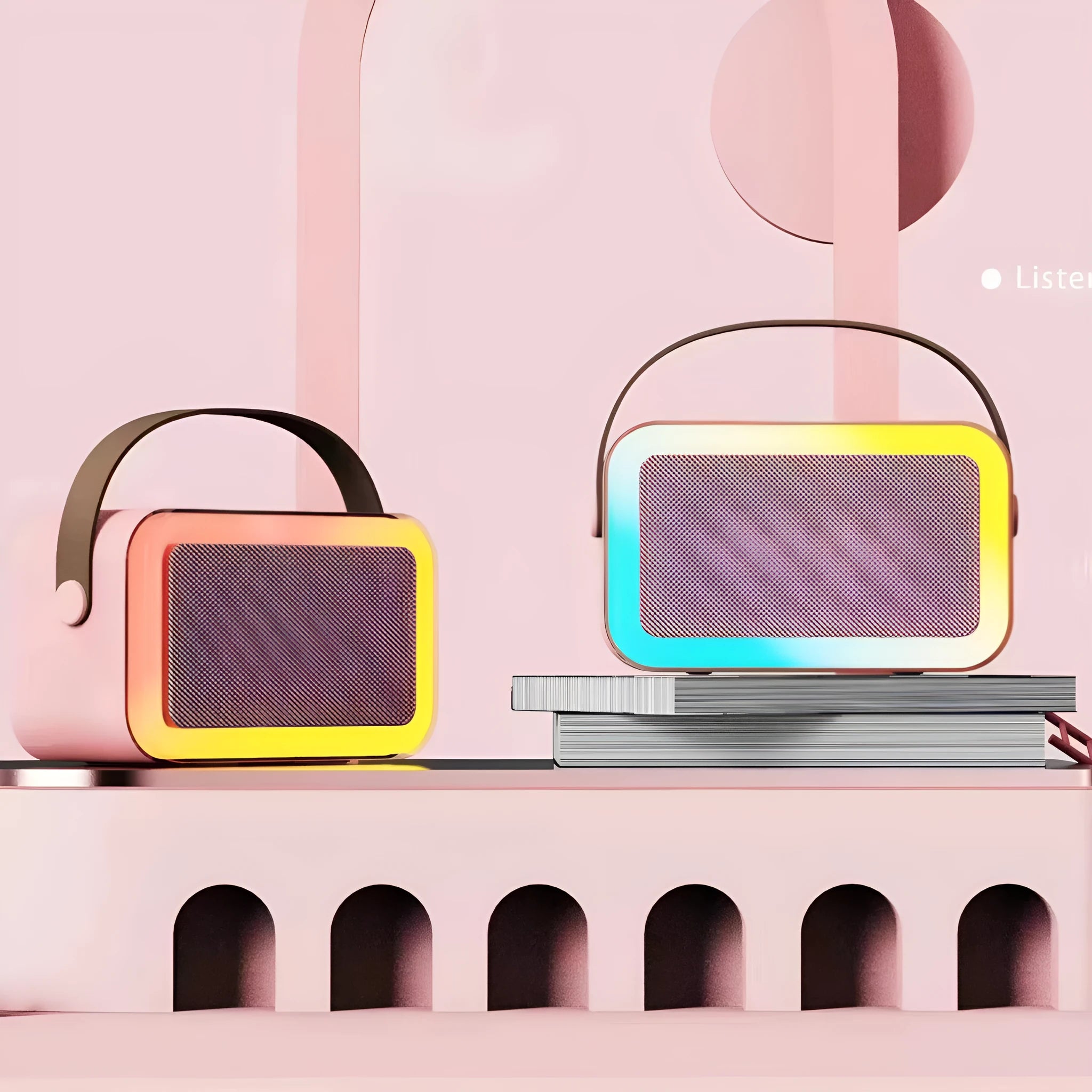 Pink portable Bluetooth speaker with microphone and coloured LED lights on a table.