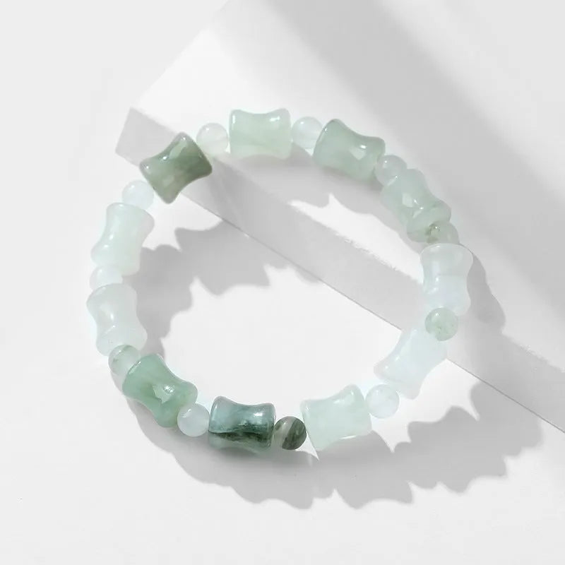 Simple beaded bracelet with chalcedony and coconut shell beads, diamond jade piece, and safety lock.