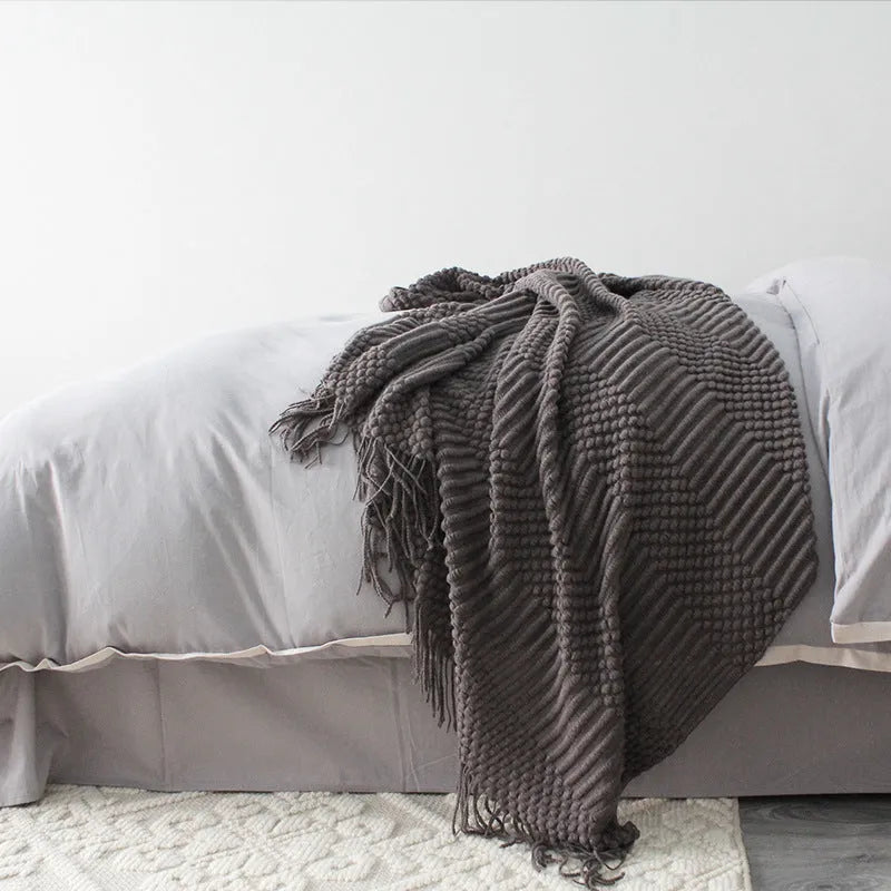 Small lightweight polyester nap blanket in dark grey, khaki, or light grey, shown folded, dimensions 127cm by 170cm.