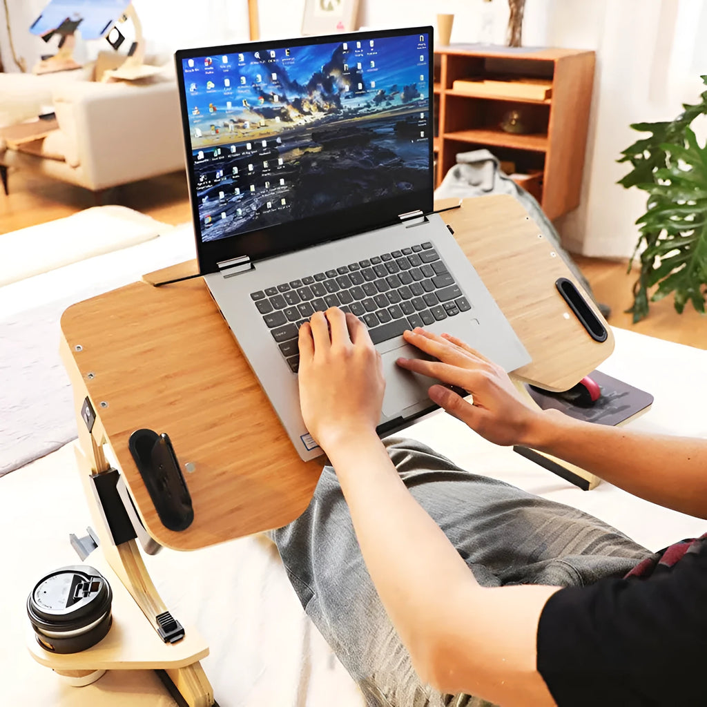 White maple wooden folding computer table set up on a bed at an adjustable angle.