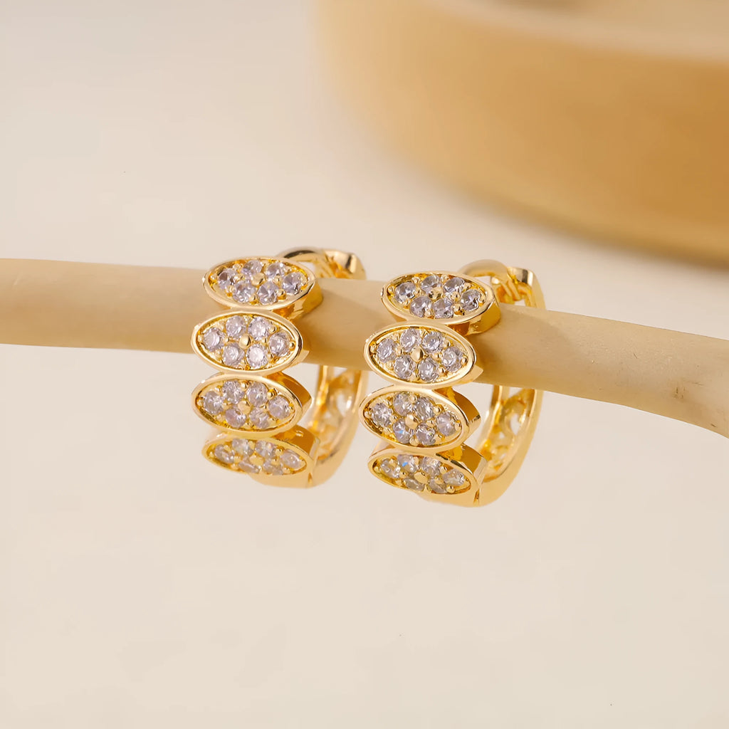 Gold women's earrings with zircon gemstones and stud fastenings