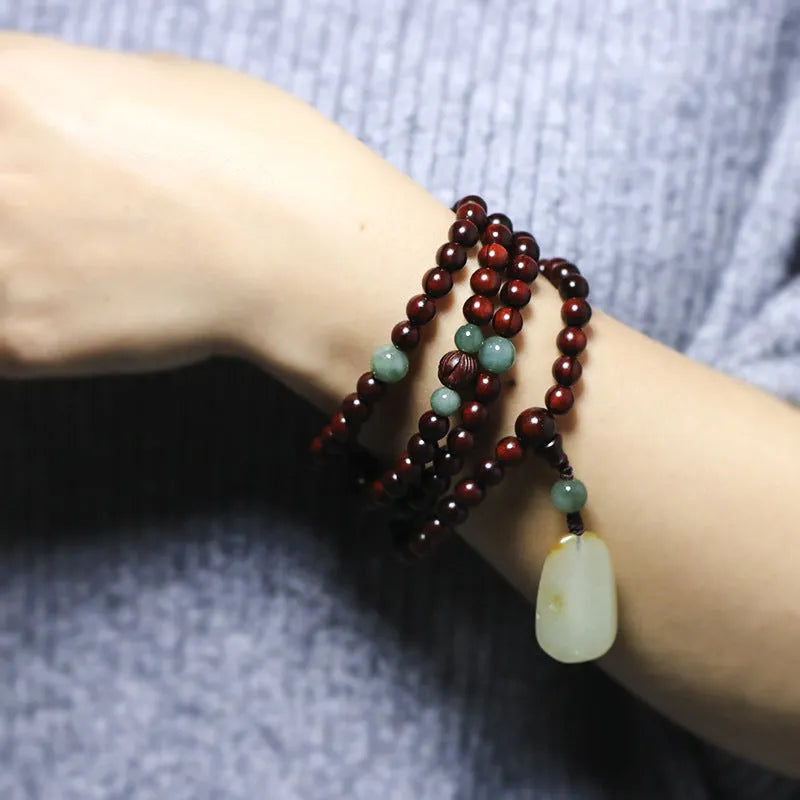 Rosewood bead bracelet with 108 beads and a carved green Hotian jade pendant.