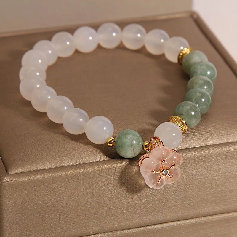 Emerald agate bracelet with white jade flower beads and pink accents on wrist