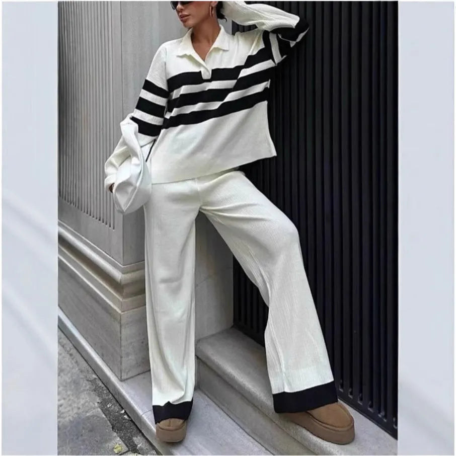 Women's black and white striped knitted top with polo collar and matching trousers casual set.