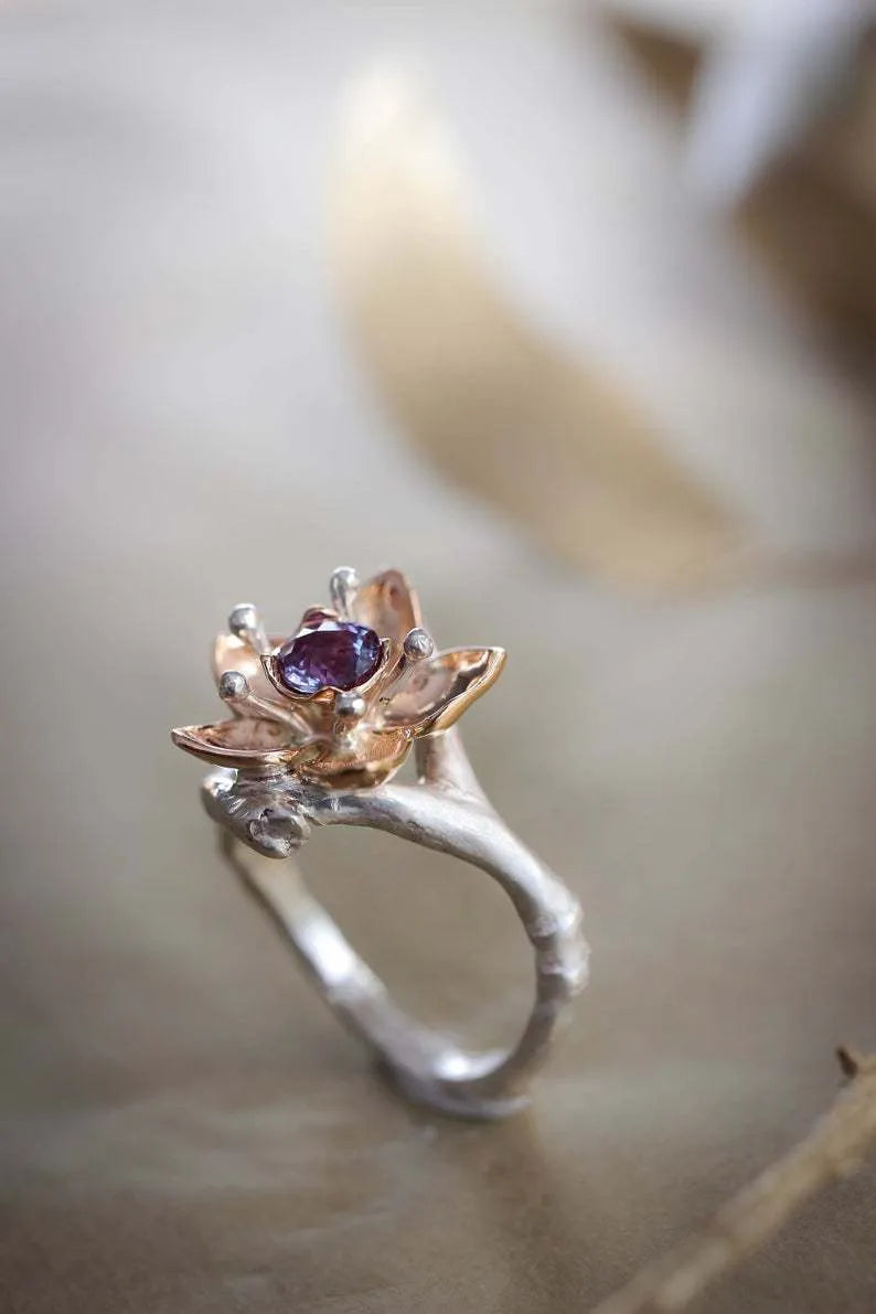 Silver two-tone floral geometric alloy women's ring on a plain background.