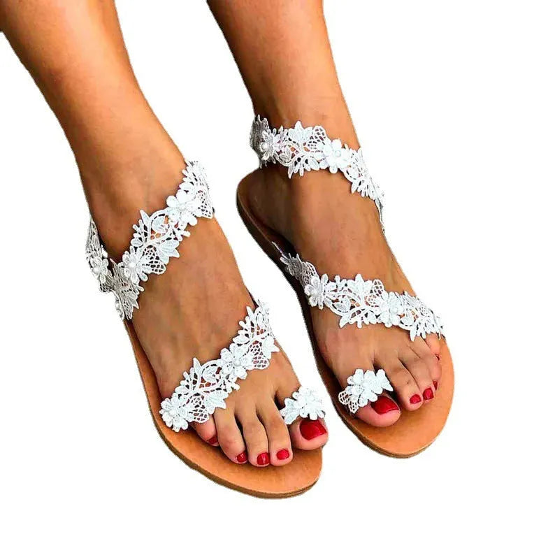 White women's flat sandals with floral patterns and rhinestones on a patent leather-look PU upper.