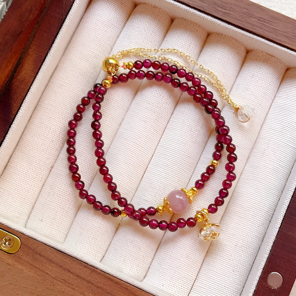 Close-up of a handmade women's natural garnet double ring bracelet in garnet colour.