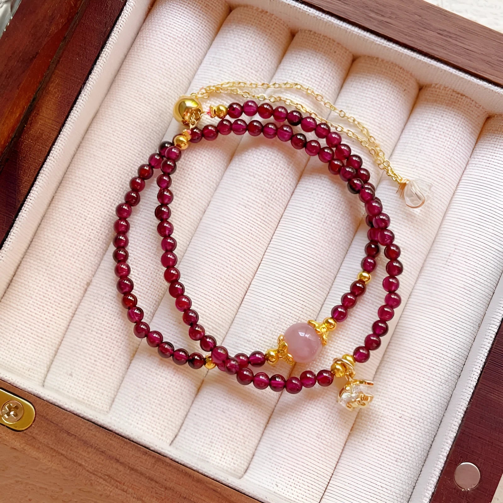 Close-up of a handmade women's natural garnet double ring bracelet in garnet colour.