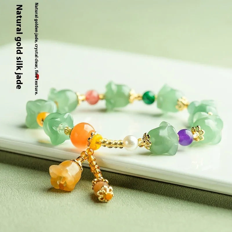 Natural Xinjiang Jinsi Jade bracelet with carved aventurine orchid beads on a wrist.