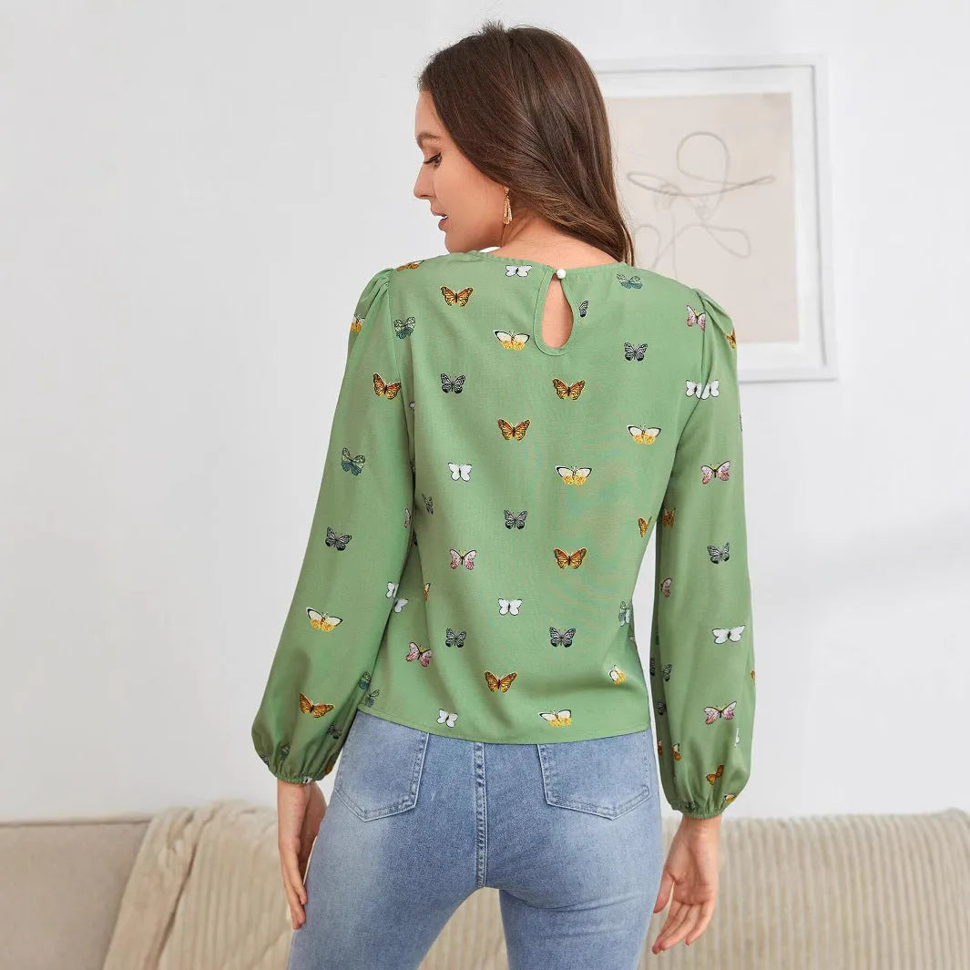 Women's green loose-fit long sleeve shirt with a colourful butterfly print.