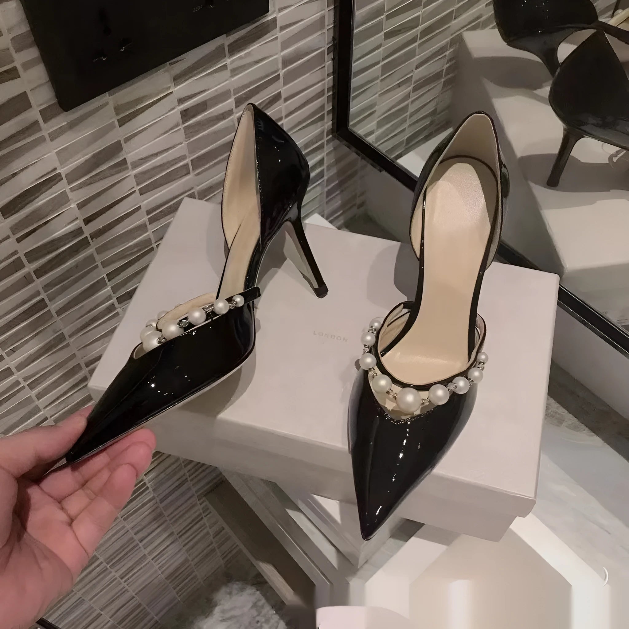 Women's pointed patent leather stiletto high heels with pearl decoration, shown in an oversleeve design.