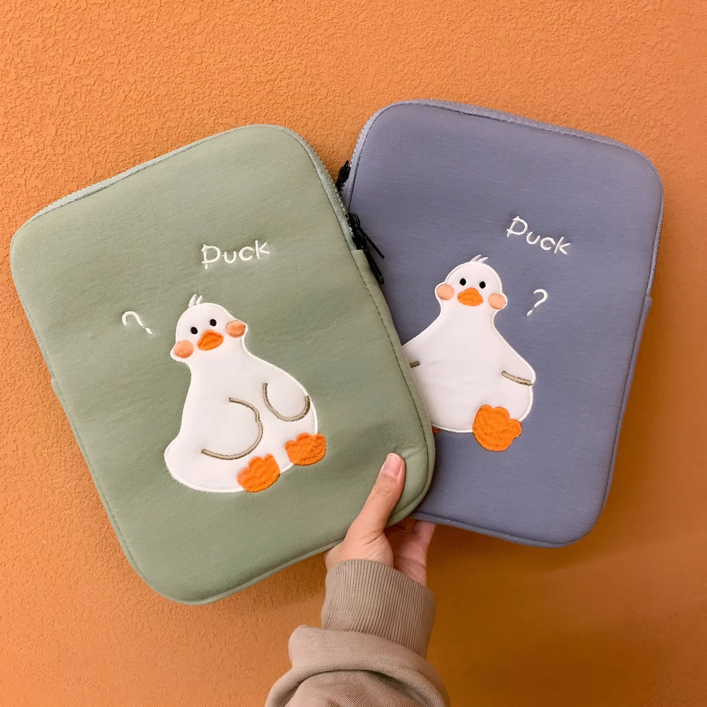 Blue cotton tablet case with cartoon duck embroidery and a zipper, shown next to a green version.