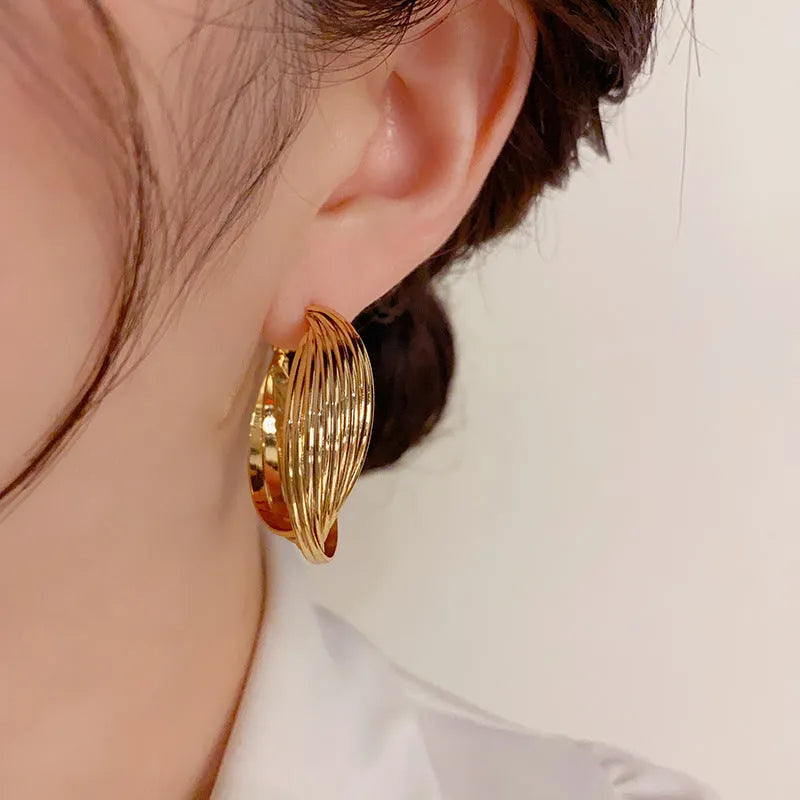 Twisted metal eardrop earring with real gold plating, geometric round shape, and stranded multi-layer design in gold colour