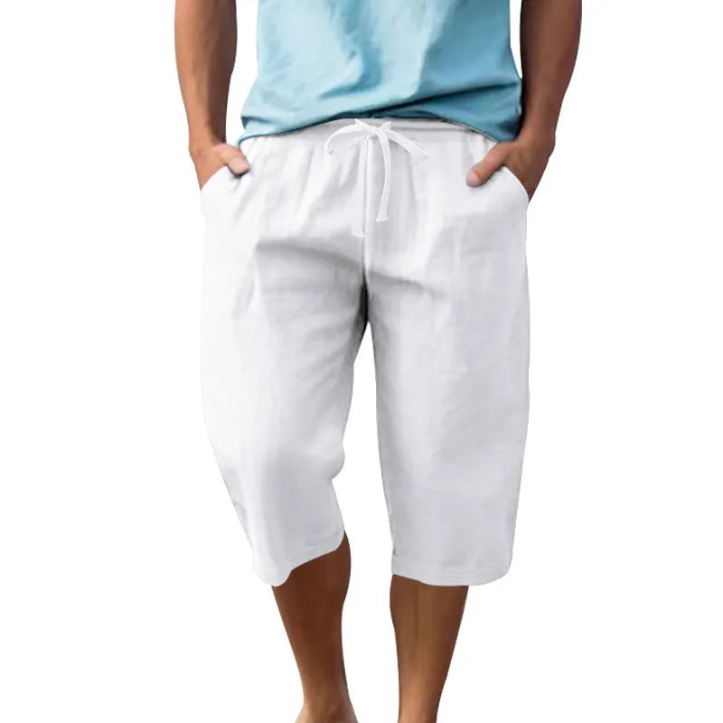 Man wearing loose, high-waisted linen shorts in a solid colour with a drawstring waist.