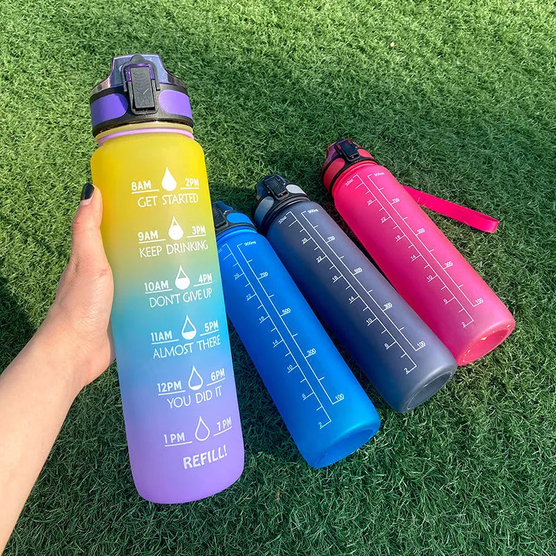 Blue and red gradient 1 litre Tritan sports water bottle with time markers and a black flip-top lid.