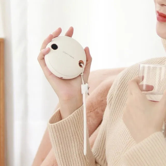 Green, pink, or white square 5000mAh hand warmer power bank with digital display next to charging cable.