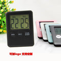 Black and white magnetic kitchen timer with large 5.5cm clock face on a steel fridge door.