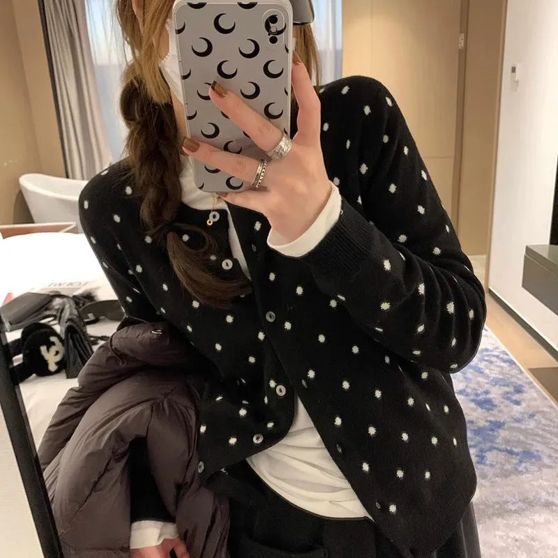 Women's grey dot pattern knitted cardigan with crochet floral detail on the front.