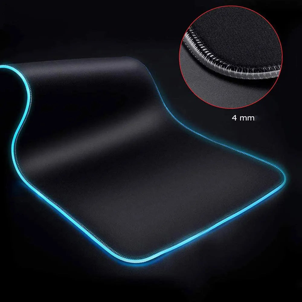Symphony RGB luminous oversized mouse pad with USB cable on a desk, showing illuminated pattern and anti-slip rubber base.