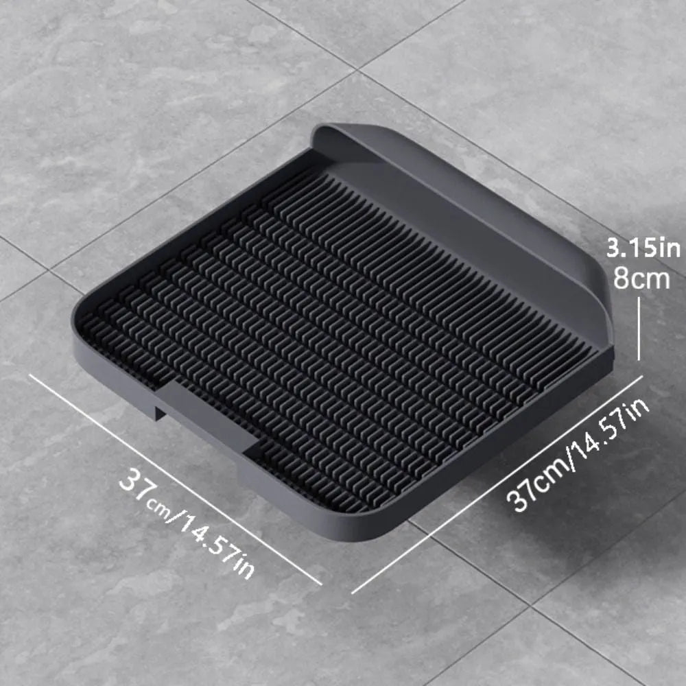 Large black cat litter pedal with slanted mouth and textured non-slip mat next to litter tray