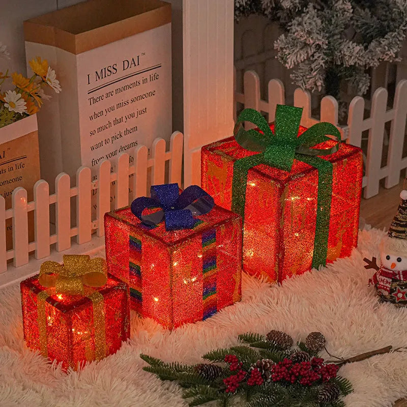 Set of three lighted Christmas gift box decorations with bows and LED lights for holiday displays