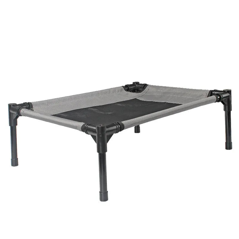 Black Oxford cloth outdoor dog bed with steel frame, shown on grass for camping use.