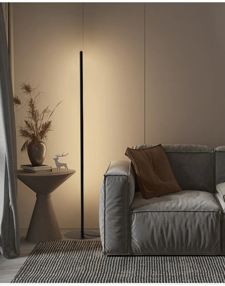 Tall, slim aluminium alloy vertical LED floor lamp standing beside a modern sofa.