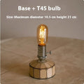 Retro wooden base bedside lamp with glass shade and USB charging cable on a table.