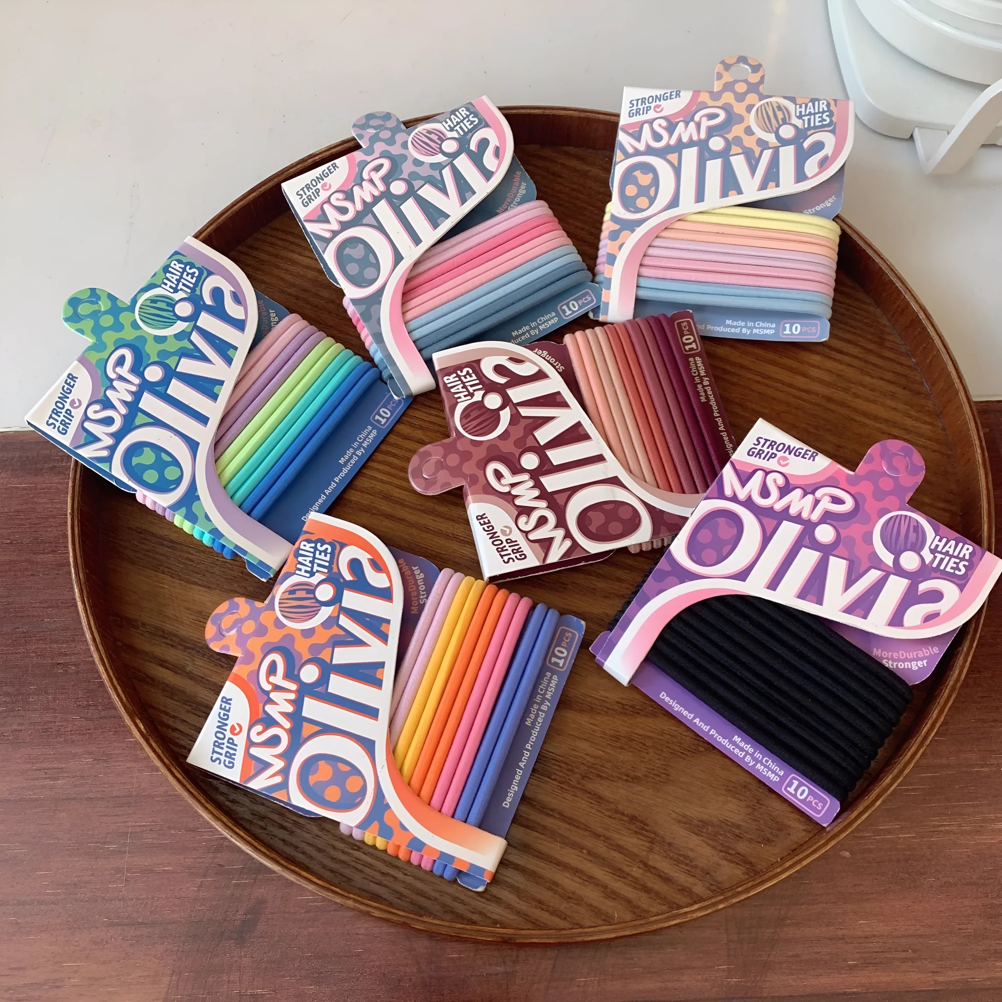 Assorted candy colour braided elastic hair bands laid flat, showing no metal parts.