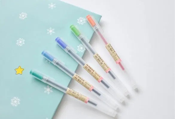 Pack of twelve black Muji 0.5mm gel pens with fine nibs, shown with pens uncapped.