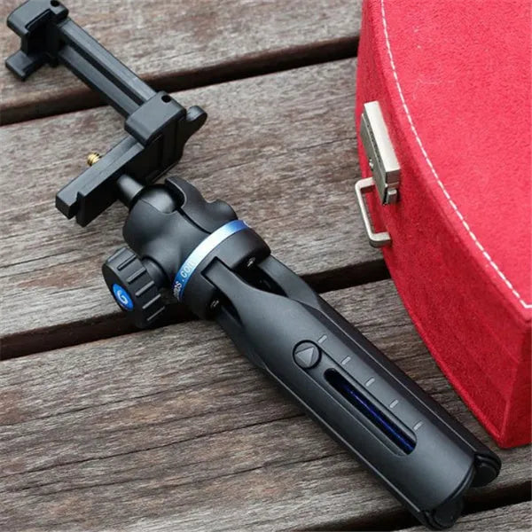 Black desktop tripod holding a mobile phone, showing adjustable bracket and plastic-aluminium construction