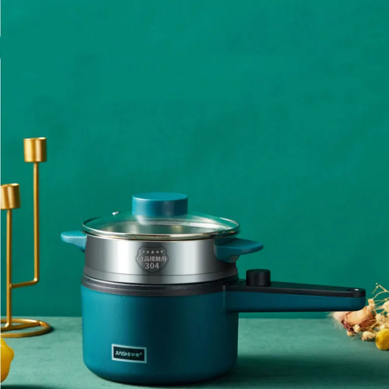 Nordic green mini electric pot with lid and steamer on countertop