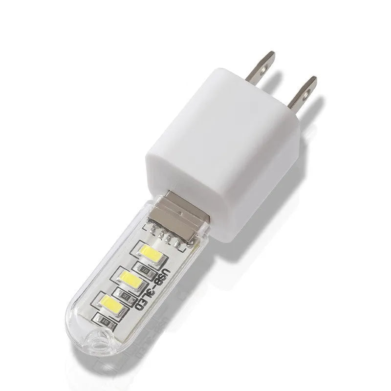 Small white USB-powered LED night light showing warm and white light options on a table.
