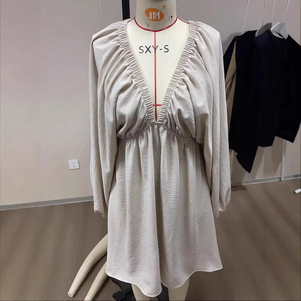 Women's apricot V-neck dress with puff sleeves and a flounced swing skirt, also available in green, black, and white.