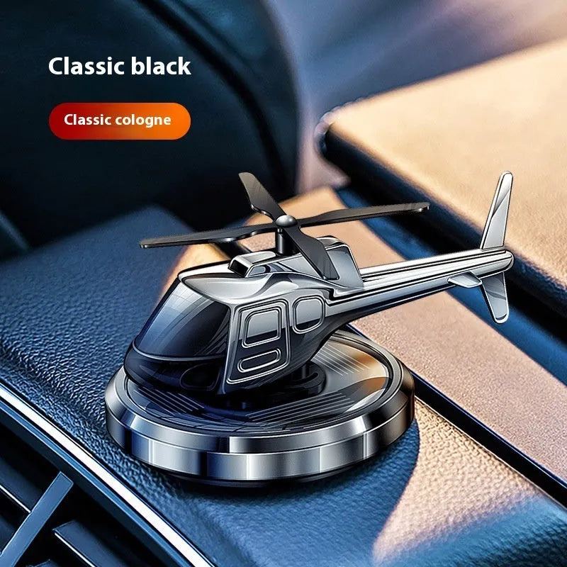 Silver metal solar helicopter car perfume ornament spinning on a car dashboard
