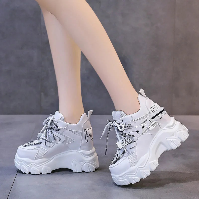 White women's low-top platform sports shoes with cross-strap and round toe on a rubber sole.