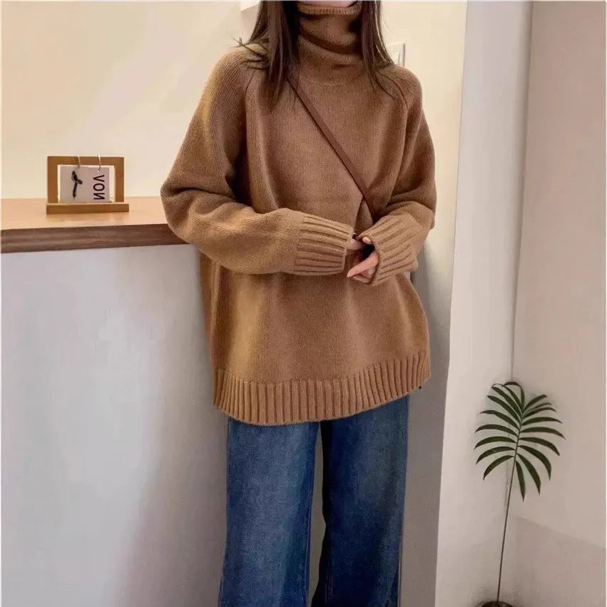 A woman wearing a thick, loose grey turtleneck sweater with a textured curling pile collar.