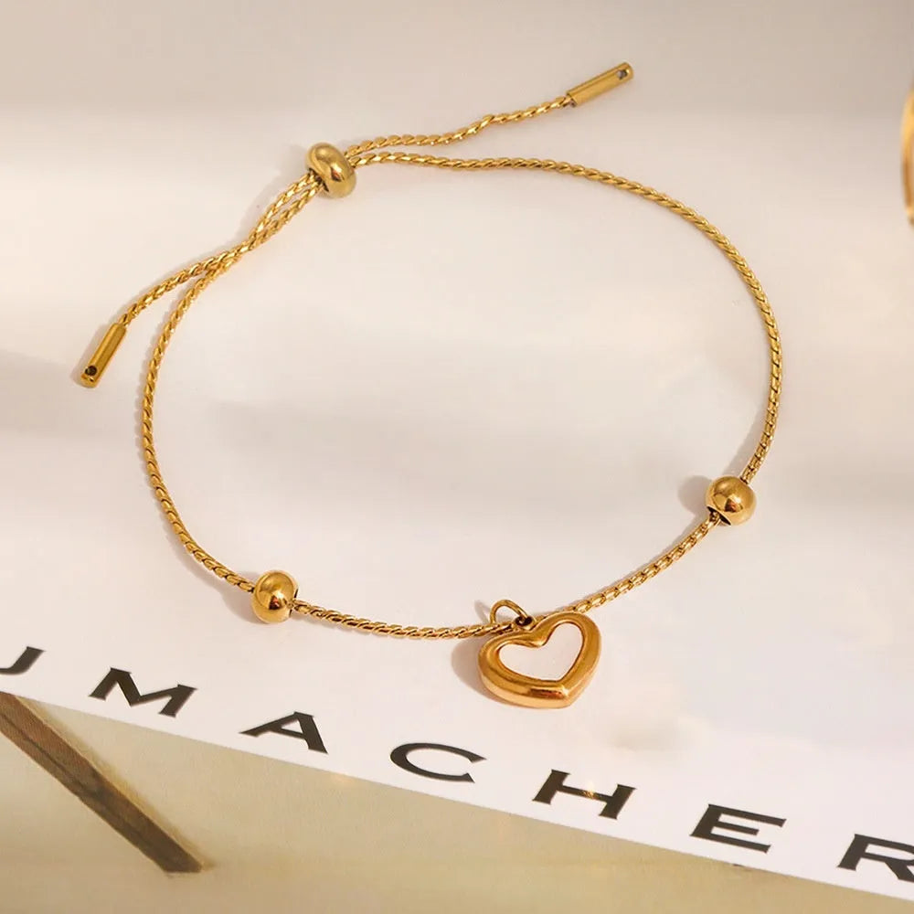 Titanium steel heart-shaped real shell bracelet with electroplated gold finish, regular chain, 31-40cm adjustable length.