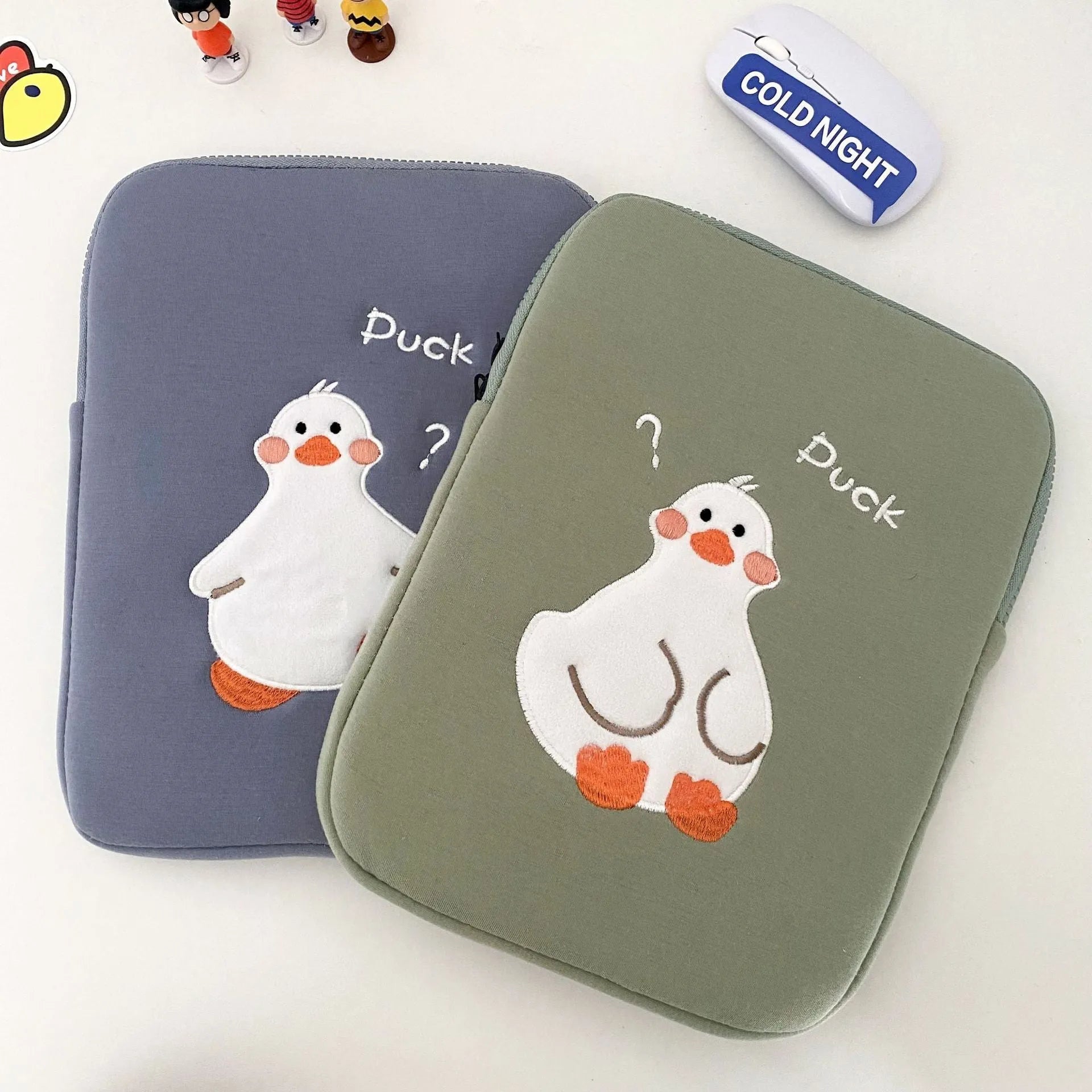 Blue cotton tablet case with cartoon duck embroidery and a zipper, shown next to a green version.