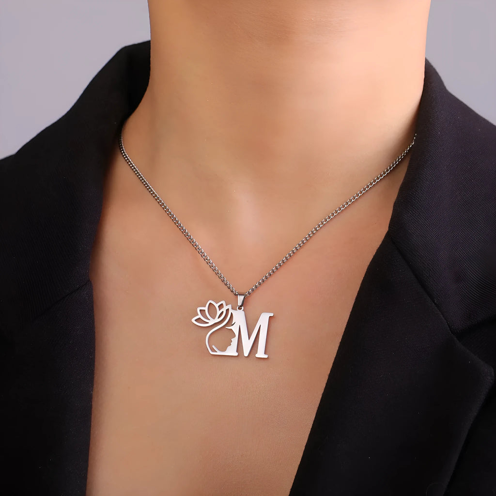 Stainless steel necklace with a cross chain and a single gold-tone letter pendant on a grey background.