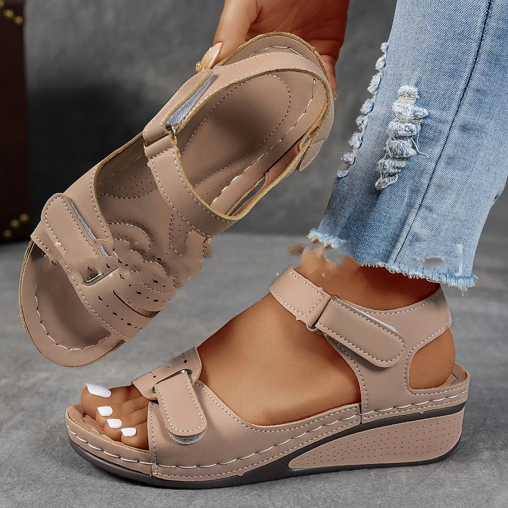 Beige wide fit sandals with thick composite sole and adjustable Velcro straps on a white background.