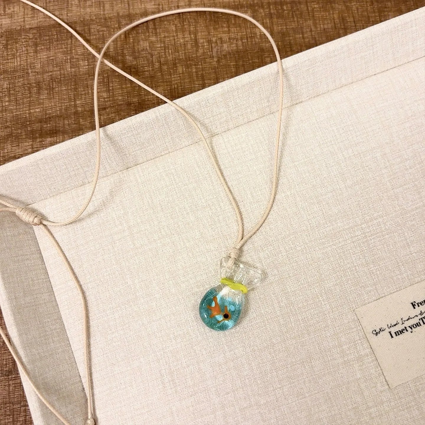 Women's pendant necklace with a coloured glaze skirt-shaped joker charm on a cotton and linen clavicle chain.