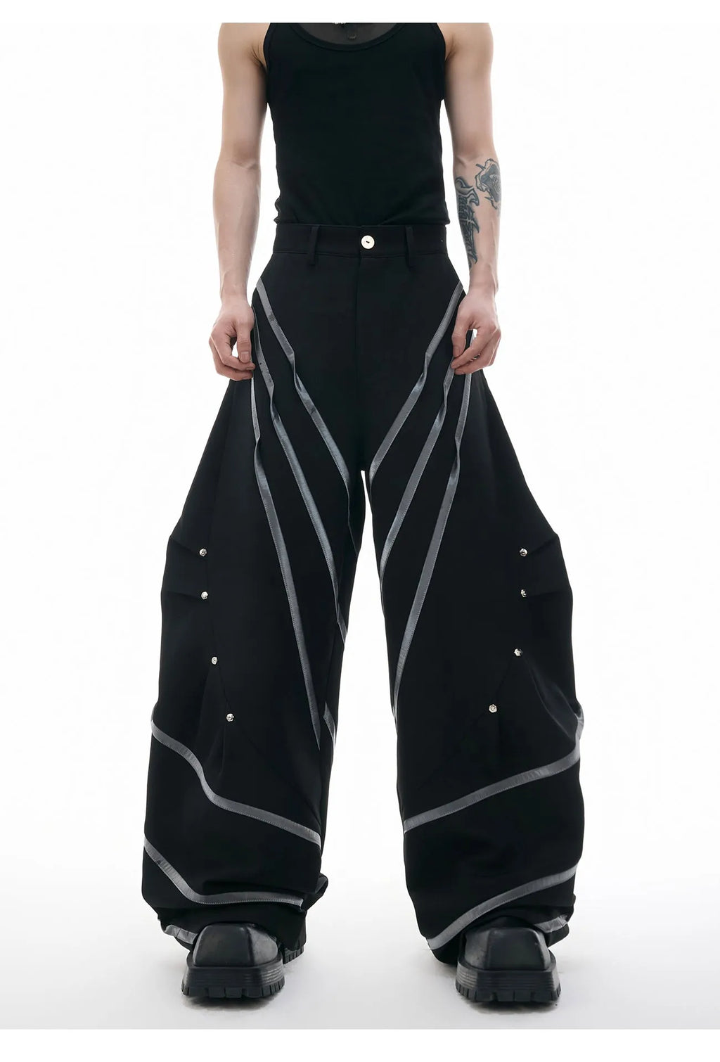 Men's black polyester trousers with metal striped rivet details and pleated front.