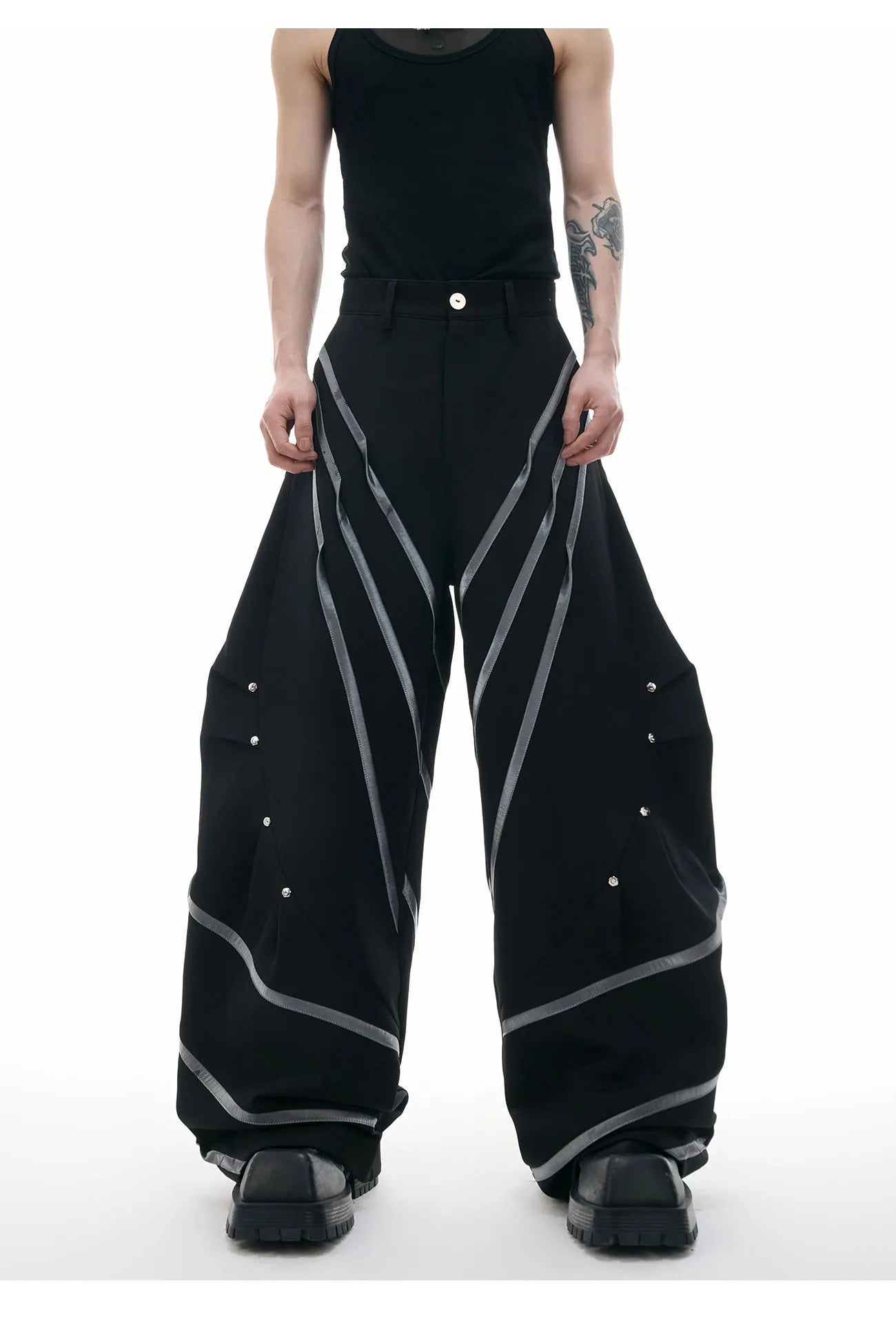 Men's black polyester trousers with metal striped rivet details and pleated front.