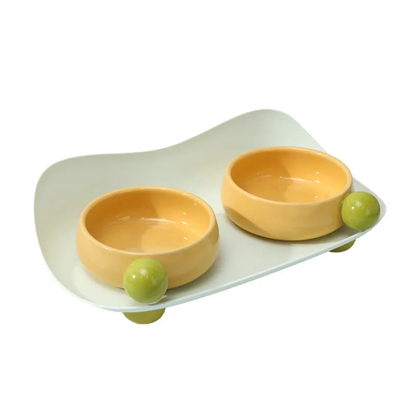 Raised ceramic pet feeding bowl set with two bowls in pink yellow colour on a non-slip base.